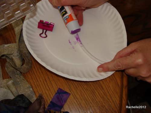 Using the paper plate as a gluing platform, spread glue all around about an inch of the cording.